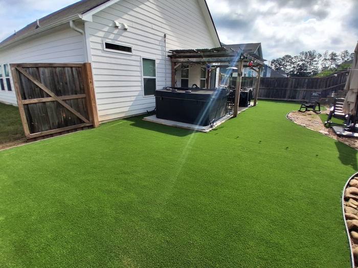 Backyard turf installation with hot tub
